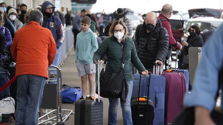 Penumpang mengantre di pemeriksaan bagasi di terminal utama Bandara Internasional Denver di Denver, Senin (3/1/2022). (AP/David Zalubowski)