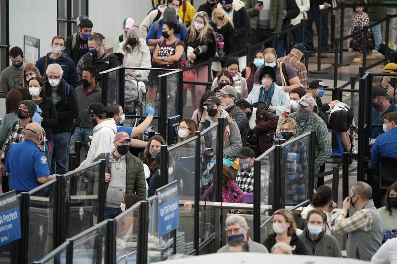 Pembatalan Penerbangan Pesawat di Bandara Internasional Denver, AS, Amerika Serikat Penumpang mengantre di pos pemeriksaan keamanan di terminal utama Bandara Internasional Denver di Denver, Senin (3/1/2022). (AP/David Zalubowski)