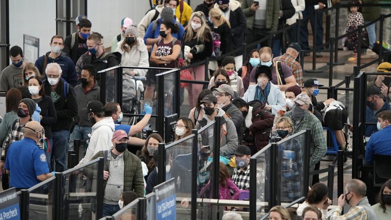 Penumpang mengantre di pos pemeriksaan keamanan di terminal utama Bandara Internasional Denver di Denver, Senin (3/1/2022).  (AP/David Zalubowski)