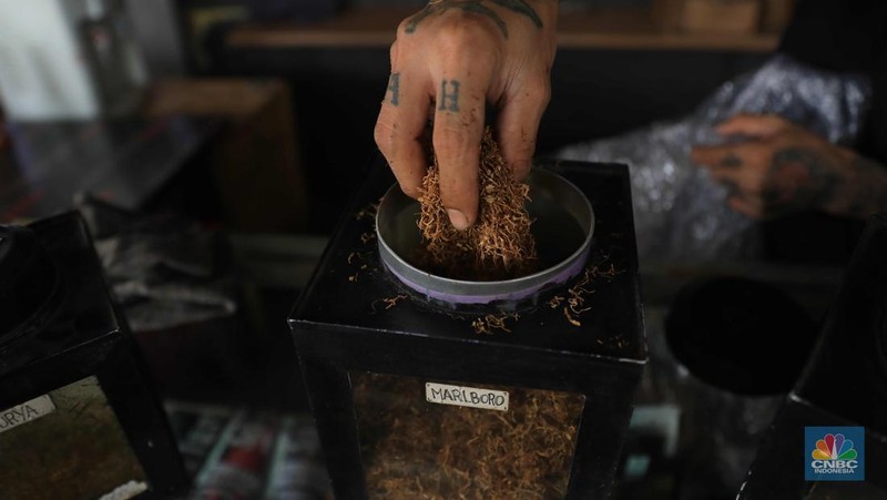 Noah penjual tembakau linting Kamarasa saat melayani pembeli di kawasan Pondok Cabe Pamulang, Selasa, 4 Januari 2022. Penjualan rokok linting kini semakin diminati masyarakat, tidak hanya kalangan tua, tetapi juga oleh anak muda. Geliat rokok linting atau linting dewe (tingwe) yang dianggap 