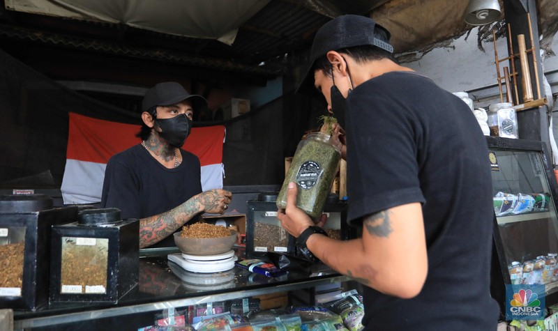 Noah penjual tembakau linting Kamarasa saat melayani pembeli di kawasan Pondok Cabe Pamulang, Selasa, 4 Januari 2022. Penjualan rokok linting kini semakin diminati masyarakat, tidak hanya kalangan tua, tetapi juga oleh anak muda. Geliat rokok linting atau linting dewe (tingwe) yang dianggap 