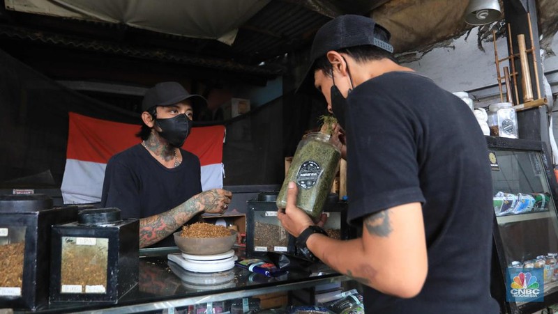 Noah penjual tembakau linting Kamarasa saat melayani pembeli di kawasan Pondok Cabe Pamulang, Selasa, 4 Januari 2022. Penjualan rokok linting kini semakin diminati masyarakat, tidak hanya kalangan tua, tetapi juga oleh anak muda. Geliat rokok linting atau linting dewe (tingwe) yang dianggap 