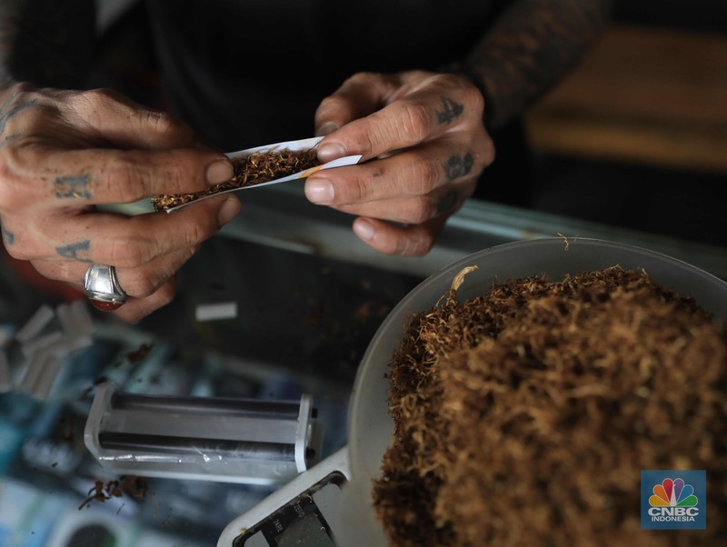 Noah penjual tembakau linting Kamarasa saat melayani pembeli di kawasan Pondok Cabe Pamulang, Selasa, 4 Januari 2022. Penjualan rokok linting kini semakin diminati masyarakat, tidak hanya kalangan tua, tetapi juga oleh anak muda. Geliat rokok linting atau linting dewe (tingwe) yang dianggap 