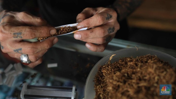 Noah penjual tembakau linting Kamarasa saat melayani pembeli di kawasan Pondok Cabe Pamulang, Selasa, 4 Januari 2022. Penjualan rokok linting kini semakin diminati masyarakat, tidak hanya kalangan tua, tetapi juga oleh anak muda. Geliat rokok linting atau linting dewe (tingwe) yang dianggap 