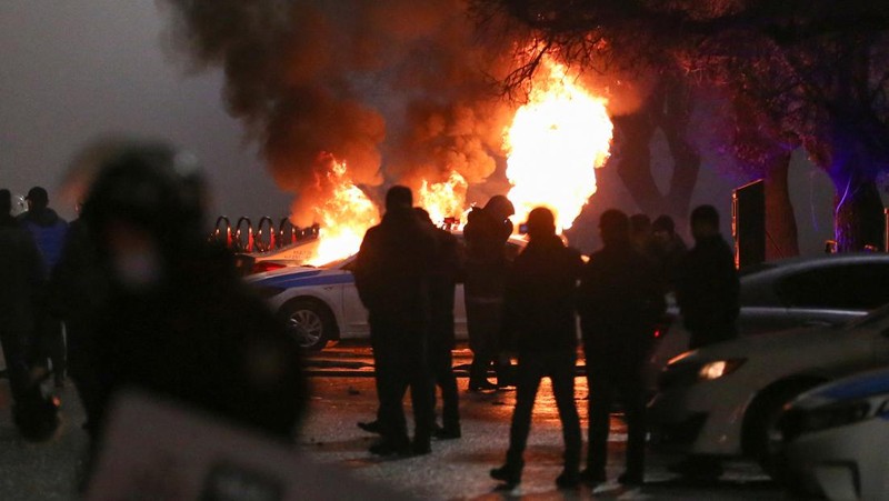Orang-orang menyerang minivan polisi saat protes terhadap kenaikan biaya LPG menyusul keputusan otoritas Kazakh untuk mengangkat batas harga bahan bakar gas cair di Almaty, Kazakhstan (5/1/2022). (REUTERS/Pavel Mikheyev)