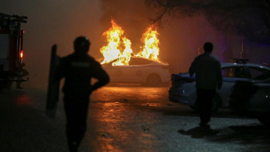 Mobil polisi terbakar saat protes terhadap kenaikan biaya LPG menyusul keputusan pihak berwenang untuk mengangkat batas harga bahan bakar gas cair di Almaty, Kazakhstan (5/1/2022). (REUTERS/Pavel Mikheyev)