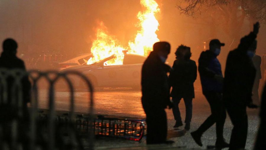 Orang-orang menyerang minivan polisi saat protes terhadap kenaikan biaya LPG menyusul keputusan otoritas Kazakh untuk mengangkat batas harga bahan bakar gas cair di Almaty, Kazakhstan (5/1/2022). (REUTERS/Pavel Mikheyev)