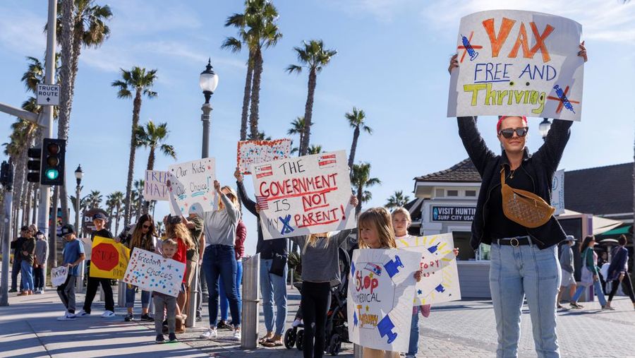 Berbagai kelompok aktivis meakukan aski menentang vaksin Covid-19 untuk anak-anak sekolah dan pekerja di Huntington Beach, California, AS (3/1/2022). (REUTERS/Mike Blake)