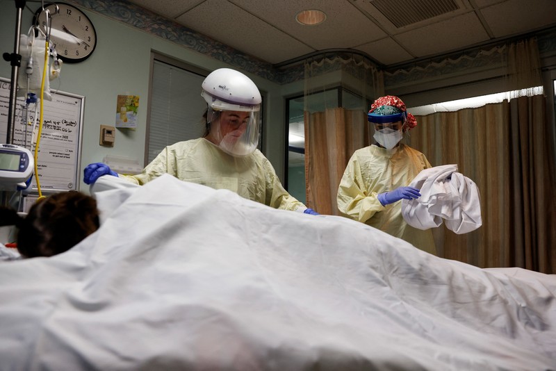 Staf medis merawat pasien penyakit virus corona (COVID-19) di ruang isolasi Unit Perawatan Intensif (ICU) di Rumah Sakit Western Reserve di Air Terjun Cuyahoga, Ohio, AS (4/1/2022). (REUTERS/Shannon Stapleton)