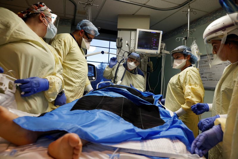 Ruang Perawatan Pasien Covid-19 di AS Staf medis merawat pasien penyakit virus corona (COVID-19) di ruang isolasi Unit Perawatan Intensif (ICU) di Rumah Sakit Western Reserve di Air Terjun Cuyahoga, Ohio, AS (4/1/2022). (REUTERS/Shannon Stapleton)