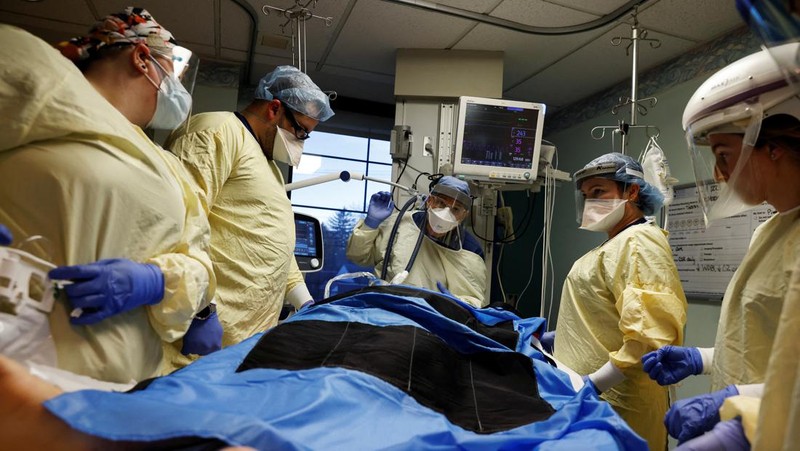 Staf medis merawat pasien penyakit virus corona (COVID-19) di ruang isolasi Unit Perawatan Intensif (ICU) di Rumah Sakit Western Reserve di Air Terjun Cuyahoga, Ohio, AS (4/1/2022). (REUTERS/Shannon Stapleton)