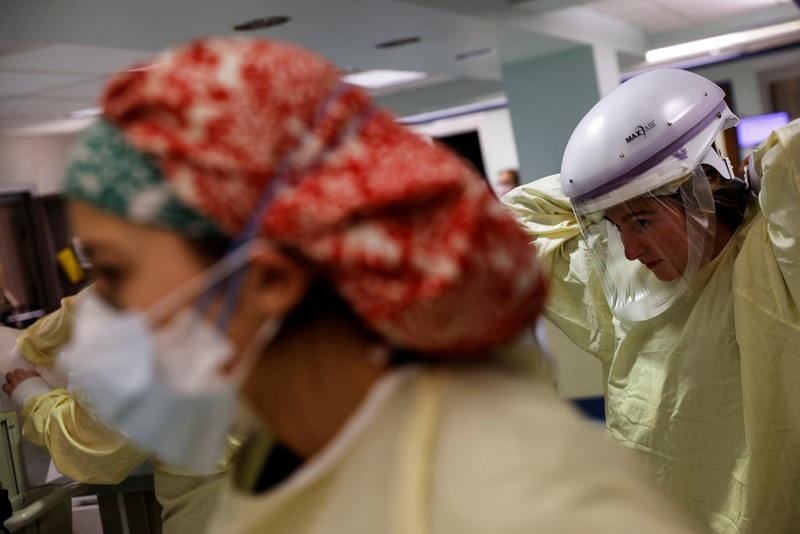 Staf medis merawat pasien penyakit virus corona (COVID-19) di ruang isolasi Unit Perawatan Intensif (ICU) di Rumah Sakit Western Reserve di Air Terjun Cuyahoga, Ohio, AS (4/1/2022). (REUTERS/Shannon Stapleton)