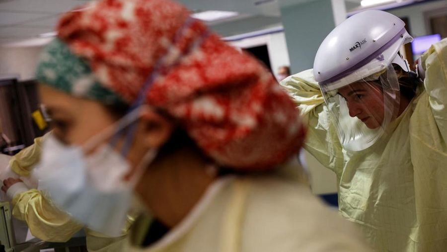 Staf medis merawat pasien penyakit virus corona (COVID-19) di ruang isolasi Unit Perawatan Intensif (ICU) di Rumah Sakit Western Reserve di Air Terjun Cuyahoga, Ohio, AS (4/1/2022). (REUTERS/Shannon Stapleton)