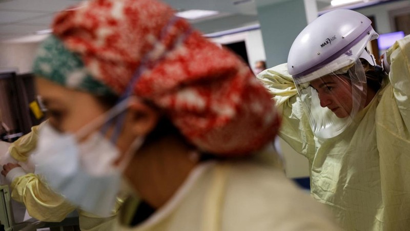 Staf medis merawat pasien penyakit virus corona (COVID-19) di ruang isolasi Unit Perawatan Intensif (ICU) di Rumah Sakit Western Reserve di Air Terjun Cuyahoga, Ohio, AS (4/1/2022). (REUTERS/Shannon Stapleton)