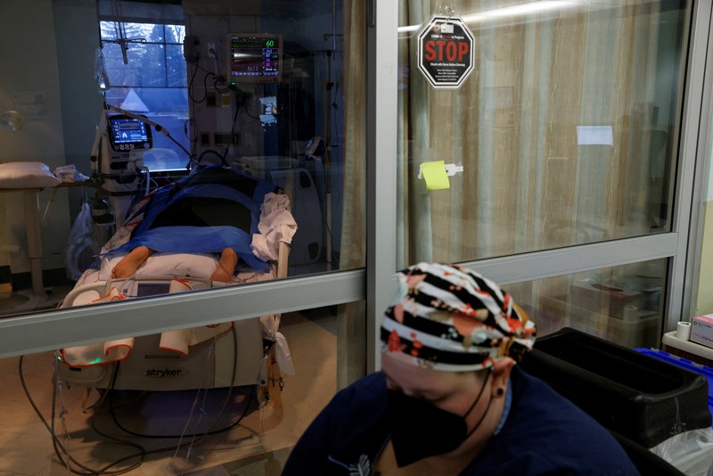 Ruang Perawatan Pasien Covid-19 di AS Staf medis merawat pasien penyakit virus corona (COVID-19) di ruang isolasi Unit Perawatan Intensif (ICU) di Rumah Sakit Western Reserve di Air Terjun Cuyahoga, Ohio, AS (4/1/2022). (REUTERS/Shannon Stapleton)