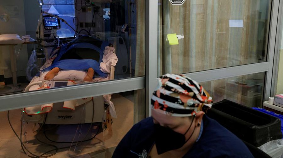 Staf medis merawat pasien penyakit virus corona (COVID-19) di ruang isolasi Unit Perawatan Intensif (ICU) di Rumah Sakit Western Reserve di Air Terjun Cuyahoga, Ohio, AS (4/1/2022). (REUTERS/Shannon Stapleton)