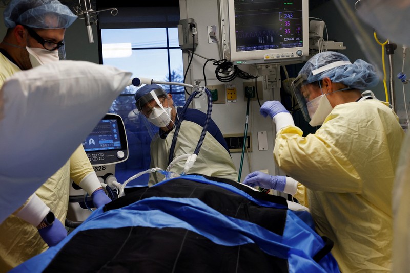 Ruang Perawatan Pasien Covid-19 di AS Staf medis merawat pasien penyakit virus corona (COVID-19) di ruang isolasi Unit Perawatan Intensif (ICU) di Rumah Sakit Western Reserve di Air Terjun Cuyahoga, Ohio, AS (4/1/2022). (REUTERS/Shannon Stapleton)