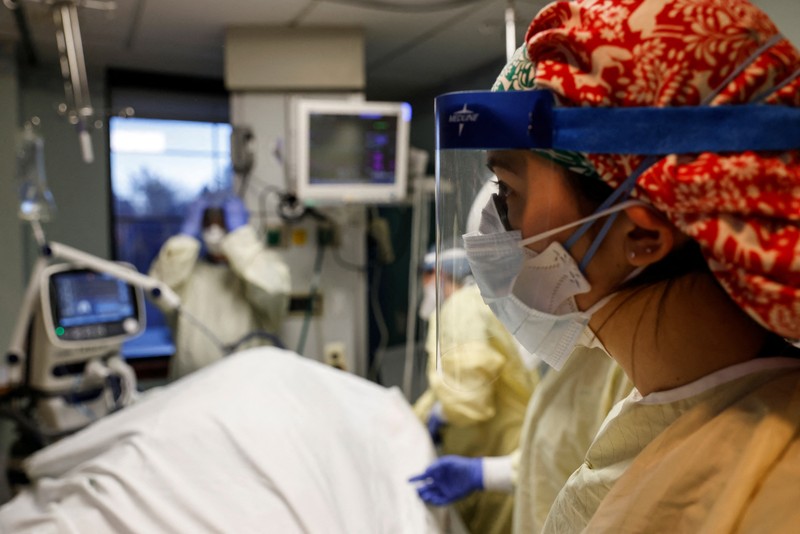 Staf medis merawat pasien penyakit virus corona (COVID-19) di ruang isolasi Unit Perawatan Intensif (ICU) di Rumah Sakit Western Reserve di Air Terjun Cuyahoga, Ohio, AS (4/1/2022). (REUTERS/Shannon Stapleton)