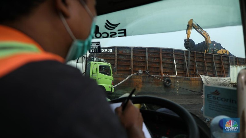 Pekerja melakukan bongkar muat batubara di Terminal Tanjung Priok, Jakarta, Kamis (6/1/2022). Pemerintah memutuskan untuk menyetop ekspor batu bara pada 1–31 Januari 2022 guna menjamin terpenuhinya pasokan komoditas tersebut untuk pembangkit listrik tenaga uap (PLTU) milik PLN dan independent power producer (IPP) dalam negeri. Kurangnya pasokan batubara dalam negeri ini akan berdampak kepada lebih dari 10 juta pelanggan PLN, mulai dari masyarakat umum hingga industri, di wilayah Jawa, Madura, Bali (Jamali) dan non-Jamali. (CNBC Indonesia/ Tri Susilo)