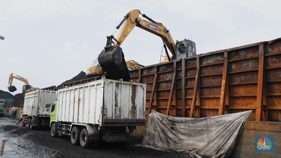 Pekerja melakukan bongkar muat batubara di Terminal Tanjung Priok, Jakarta, Kamis (6/1/2022). Pemerintah memutuskan untuk menyetop ekspor batu bara pada 1–31 Januari 2022 guna menjamin terpenuhinya pasokan komoditas tersebut untuk pembangkit listrik tenaga uap (PLTU) milik PLN dan independent power producer (IPP) dalam negeri. Kurangnya pasokan batubara dalam negeri ini akan berdampak kepada lebih dari 10 juta pelanggan PLN, mulai dari masyarakat umum hingga industri, di wilayah Jawa, Madura, Bali (Jamali) dan non-Jamali. (CNBC Indonesia/ Tri Susilo)