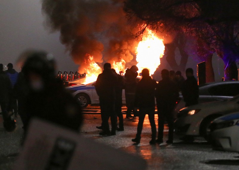 Pasukan kepolisian berjaga saat sejumlah warga berdemo memprotes pemerintah setelah keputusan menaikkan batas harga bahan bakar gas cair di Almaty, Kazakhstan, Kamis (6/1/2022). (REUTERS/Mariya Gordeyeva)