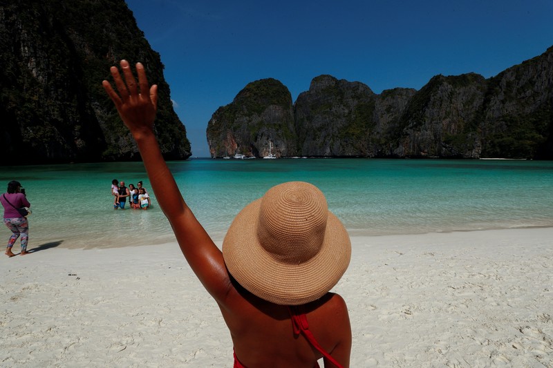 Turis mengunjungi teluk Maya setelah Thailand membuka kembali pantainya yang terkenal di dunia setelah ditutup selama lebih dari tiga tahun untuk pemulihan ekosistem dari dampak overtourism di provinsi Krabi, Thailand, Selasa (3/1/2022). (REUTERS/Athit Perawongmetha)