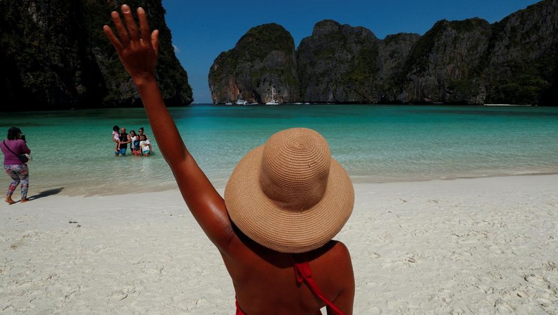 Turis mengunjungi teluk Maya setelah Thailand membuka kembali pantainya yang terkenal di dunia setelah ditutup selama lebih dari tiga tahun untuk pemulihan ekosistem dari dampak overtourism di provinsi Krabi, Thailand, Selasa (3/1/2022). (REUTERS/Athit Perawongmetha)