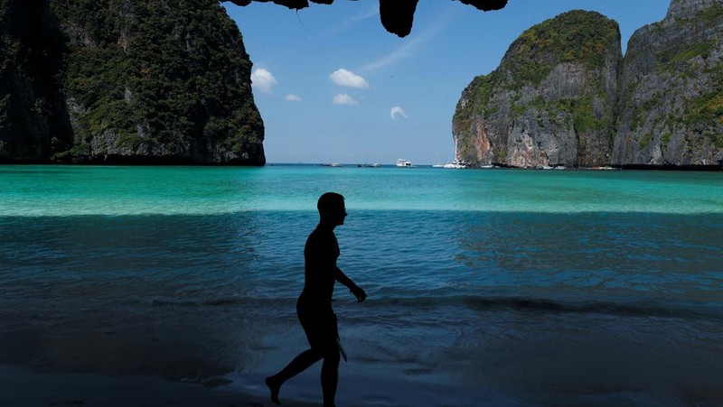 Turis mengunjungi teluk Maya setelah Thailand membuka kembali pantainya yang terkenal di dunia setelah ditutup selama lebih dari tiga tahun untuk pemulihan ekosistem dari dampak overtourism di provinsi Krabi, Thailand, Selasa (3/1/2022). (REUTERS/Athit Perawongmetha)