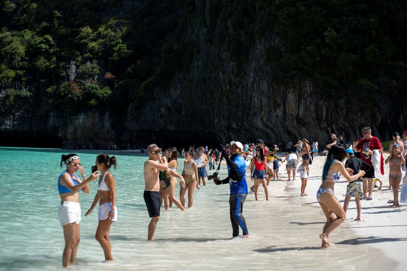 Turis mengunjungi teluk Maya di provinsi Krabi, Thailand Turis mengunjungi teluk Maya setelah Thailand membuka kembali pantainya yang terkenal di dunia setelah ditutup selama lebih dari tiga tahun untuk pemulihan ekosistem dari dampak overtourism di provinsi Krabi, Thailand, Selasa (3/1/2022). (REUTERS/Athit Perawongmetha)