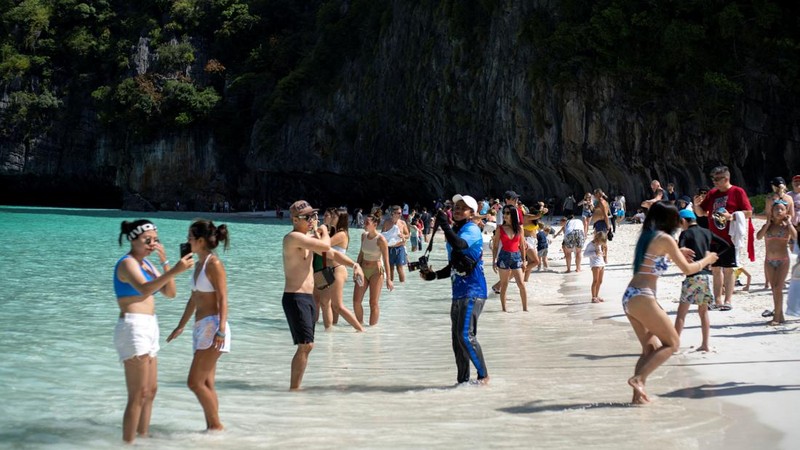 Turis mengunjungi teluk Maya setelah Thailand membuka kembali pantainya yang terkenal di dunia setelah ditutup selama lebih dari tiga tahun untuk pemulihan ekosistem dari dampak overtourism di provinsi Krabi, Thailand, Selasa (3/1/2022). (REUTERS/Athit Perawongmetha)