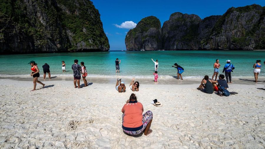 Turis mengunjungi teluk Maya setelah Thailand membuka kembali pantainya yang terkenal di dunia setelah ditutup selama lebih dari tiga tahun untuk pemulihan ekosistem dari dampak overtourism di provinsi Krabi, Thailand, Selasa (3/1/2022). (REUTERS/Athit Perawongmetha)