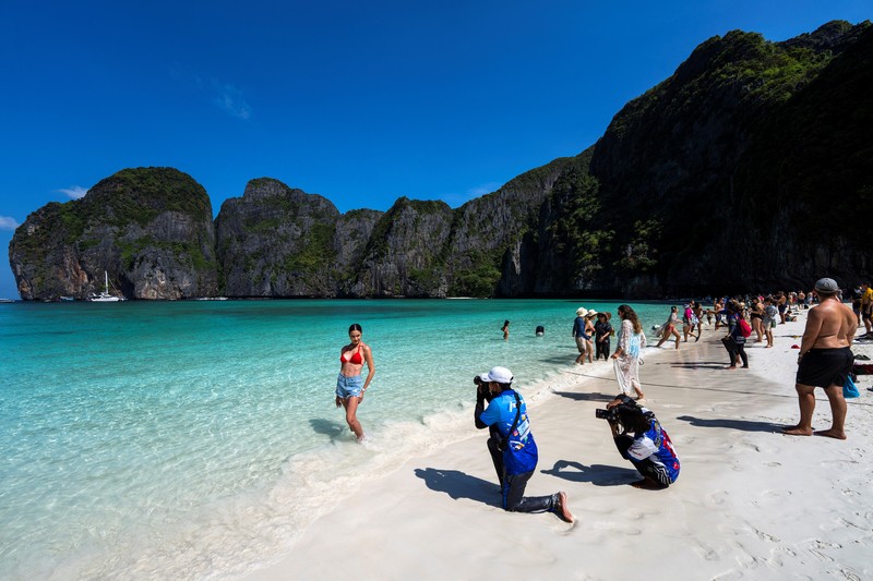 Turis mengunjungi teluk Maya di provinsi Krabi, Thailand Turis mengunjungi teluk Maya setelah Thailand membuka kembali pantainya yang terkenal di dunia setelah ditutup selama lebih dari tiga tahun untuk pemulihan ekosistem dari dampak overtourism di provinsi Krabi, Thailand, Selasa (3/1/2022). (REUTERS/Athit Perawongmetha)