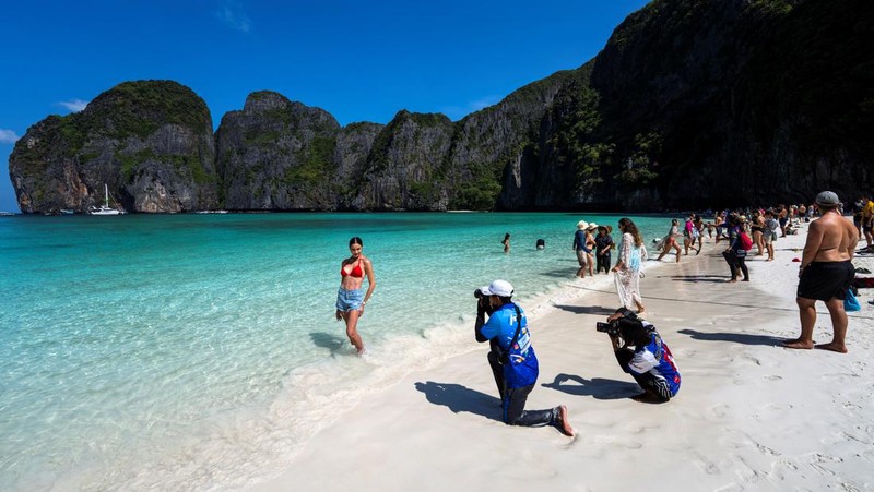 Turis mengunjungi teluk Maya setelah Thailand membuka kembali pantainya yang terkenal di dunia setelah ditutup selama lebih dari tiga tahun untuk pemulihan ekosistem dari dampak overtourism di provinsi Krabi, Thailand, Selasa (3/1/2022). (REUTERS/Athit Perawongmetha)