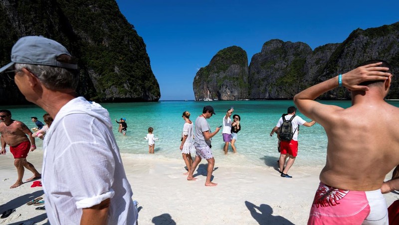 Turis mengunjungi teluk Maya setelah Thailand membuka kembali pantainya yang terkenal di dunia setelah ditutup selama lebih dari tiga tahun untuk pemulihan ekosistem dari dampak overtourism di provinsi Krabi, Thailand, Selasa (3/1/2022). (REUTERS/Athit Perawongmetha)