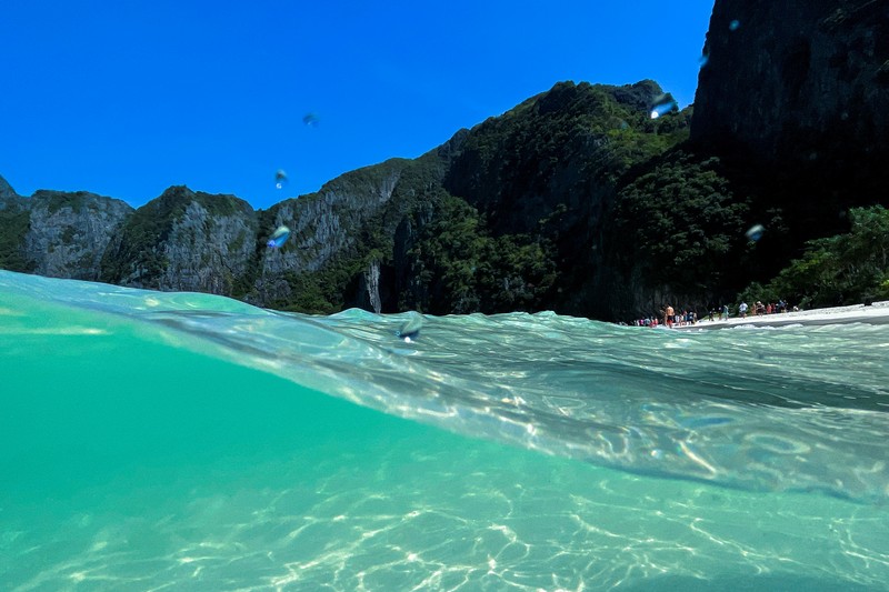 Turis mengunjungi teluk Maya di provinsi Krabi, Thailand Turis mengunjungi teluk Maya setelah Thailand membuka kembali pantainya yang terkenal di dunia setelah ditutup selama lebih dari tiga tahun untuk pemulihan ekosistem dari dampak overtourism di provinsi Krabi, Thailand, Selasa (3/1/2022). (REUTERS/Athit Perawongmetha)