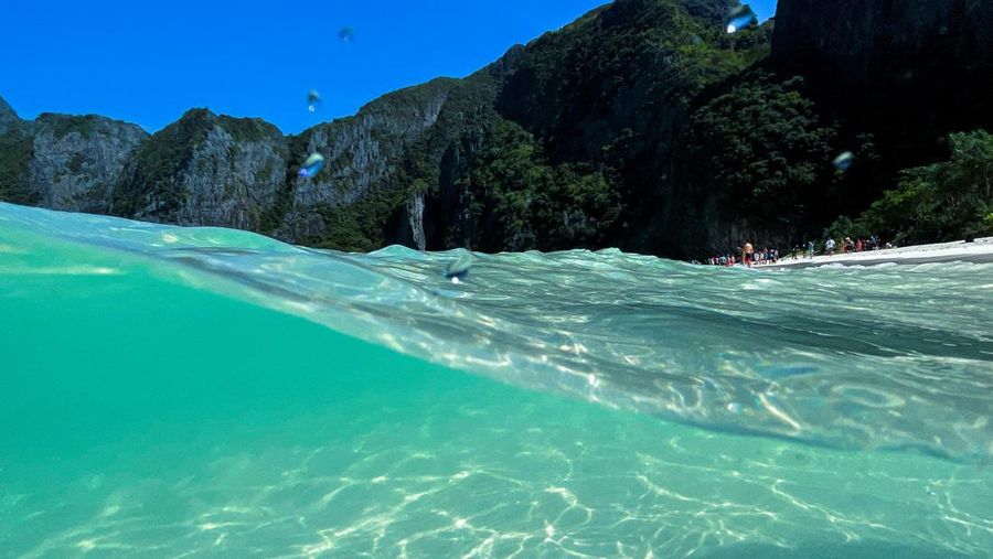 Turis mengunjungi teluk Maya setelah Thailand membuka kembali pantainya yang terkenal di dunia setelah ditutup selama lebih dari tiga tahun untuk pemulihan ekosistem dari dampak overtourism di provinsi Krabi, Thailand, Selasa (3/1/2022). (REUTERS/Athit Perawongmetha)