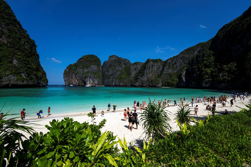 Turis mengunjungi teluk Maya setelah Thailand membuka kembali pantainya yang terkenal di dunia setelah ditutup selama lebih dari tiga tahun untuk pemulihan ekosistem dari dampak overtourism di provinsi Krabi, Thailand, Selasa (3/1/2022). (REUTERS/Athit Perawongmetha)
