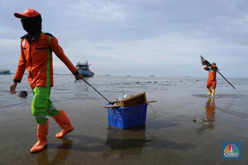 bersih-bersih usai banjir rob di pelabuhan kali adem Petugas PPSU membersihkan sampah setelah terjadi banjir rob di Pelabuhan Kali Adem, Muara Angke, Jakarta, Jumat (7/1/2022). Setelah terendam banjir rob, petugas PPSU tetap sigap bersihkan sampah yang mengambang terbawa air laut. Suku Dinas Lingkungan Hidup (LH) Kota Administrasi Jakarta Utara membentuk tim khusus yang bertugas untuk menangani sampah pasca banjir rob yang terjadi di beberapa wilayah seperti di Muara Angke dan Sunda Kelapa. Menurut petugas PPSU