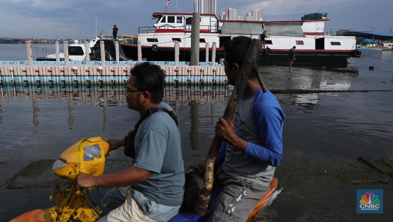 Petugas PPSU membersihkan sampah setelah terjadi banjir rob di Pelabuhan Kali Adem, Muara Angke, Jakarta, Jumat (7/1/2022). Setelah terendam banjir rob, petugas PPSU tetap sigap bersihkan sampah yang mengambang terbawa air laut. Suku Dinas Lingkungan Hidup (LH) Kota Administrasi Jakarta Utara membentuk tim khusus yang bertugas untuk menangani sampah pasca banjir rob yang terjadi di beberapa wilayah seperti di Muara Angke dan Sunda Kelapa. Menurut petugas PPSU 