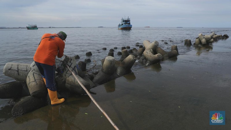 Petugas PPSU membersihkan sampah setelah terjadi banjir rob di Pelabuhan Kali Adem, Muara Angke, Jakarta, Jumat (7/1/2022). Setelah terendam banjir rob, petugas PPSU tetap sigap bersihkan sampah yang mengambang terbawa air laut. Suku Dinas Lingkungan Hidup (LH) Kota Administrasi Jakarta Utara membentuk tim khusus yang bertugas untuk menangani sampah pasca banjir rob yang terjadi di beberapa wilayah seperti di Muara Angke dan Sunda Kelapa. Menurut petugas PPSU 