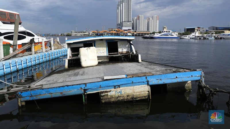 Petugas PPSU membersihkan sampah setelah terjadi banjir rob di Pelabuhan Kali Adem, Muara Angke, Jakarta, Jumat (7/1/2022). Setelah terendam banjir rob, petugas PPSU tetap sigap bersihkan sampah yang mengambang terbawa air laut. Suku Dinas Lingkungan Hidup (LH) Kota Administrasi Jakarta Utara membentuk tim khusus yang bertugas untuk menangani sampah pasca banjir rob yang terjadi di beberapa wilayah seperti di Muara Angke dan Sunda Kelapa. Menurut petugas PPSU 