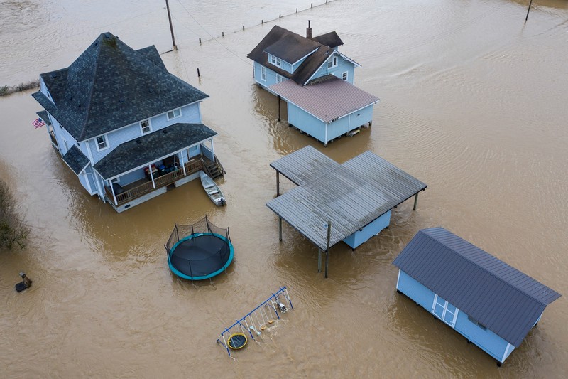USA-WEATHER/FLOODING Chehalis fire and rescue team members bring a stranded resident to dry land after floodwaters threatened their home following heavy rain in Chehalis, Washington, U.S., January 7, 2022. REUTERS/Nathan Howard