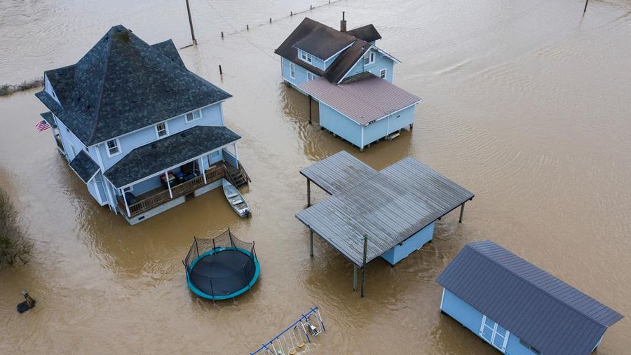 Chehalis fire and rescue team members bring a stranded resident to dry land after floodwaters threatened their home following heavy rain in Chehalis, Washington, U.S., January 7, 2022. REUTERS/Nathan Howard