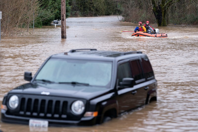 USA-WEATHER/FLOODING Chehalis fire and rescue team members bring a stranded resident to dry land after floodwaters threatened their home following heavy rain in Chehalis, Washington, U.S., January 7, 2022. REUTERS/Nathan Howard