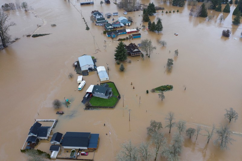 USA-WEATHER/FLOODING Chehalis fire and rescue team members bring a stranded resident to dry land after floodwaters threatened their home following heavy rain in Chehalis, Washington, U.S., January 7, 2022. REUTERS/Nathan Howard