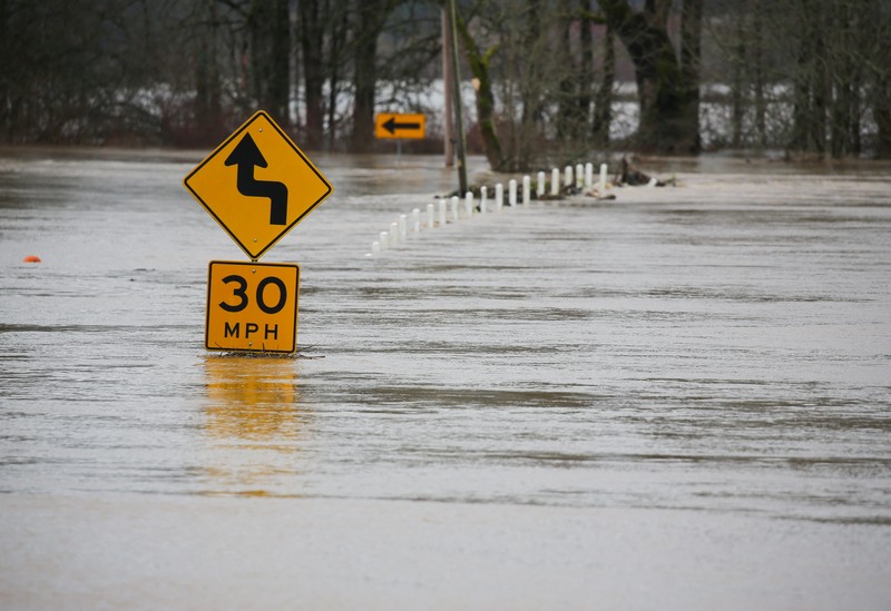 USA-WEATHER/FLOODING Chehalis fire and rescue team members bring a stranded resident to dry land after floodwaters threatened their home following heavy rain in Chehalis, Washington, U.S., January 7, 2022. REUTERS/Nathan Howard