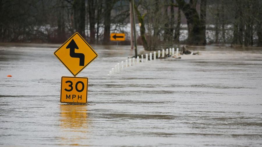 Chehalis fire and rescue team members bring a stranded resident to dry land after floodwaters threatened their home following heavy rain in Chehalis, Washington, U.S., January 7, 2022. REUTERS/Nathan Howard
