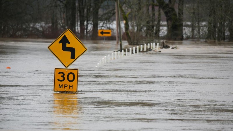 Chehalis fire and rescue team members bring a stranded resident to dry land after floodwaters threatened their home following heavy rain in Chehalis, Washington, U.S., January 7, 2022. REUTERS/Nathan Howard