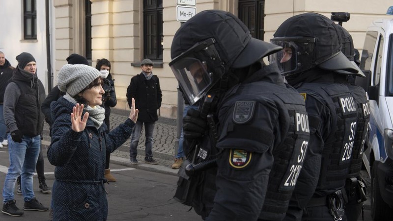 Demonstran memegang spanduk bertuliskan 