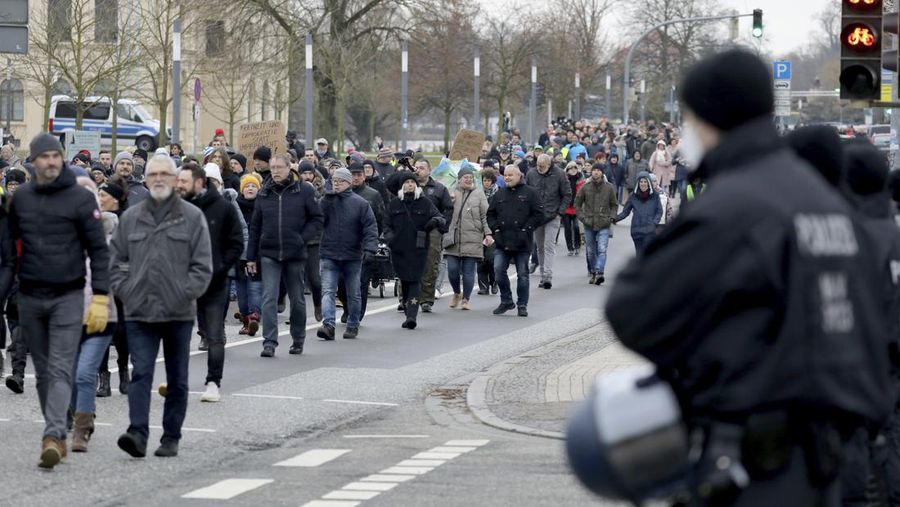 Demonstran memegang spanduk bertuliskan 